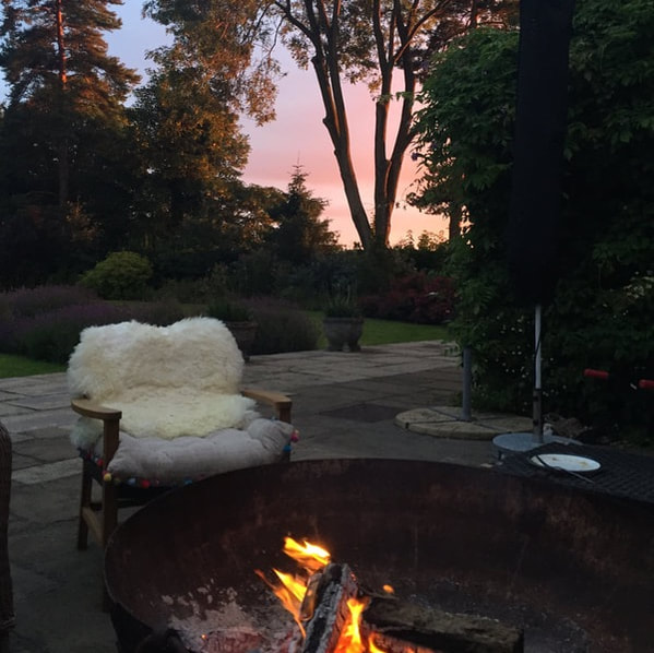 Garden in the evening with chairs and fire pit